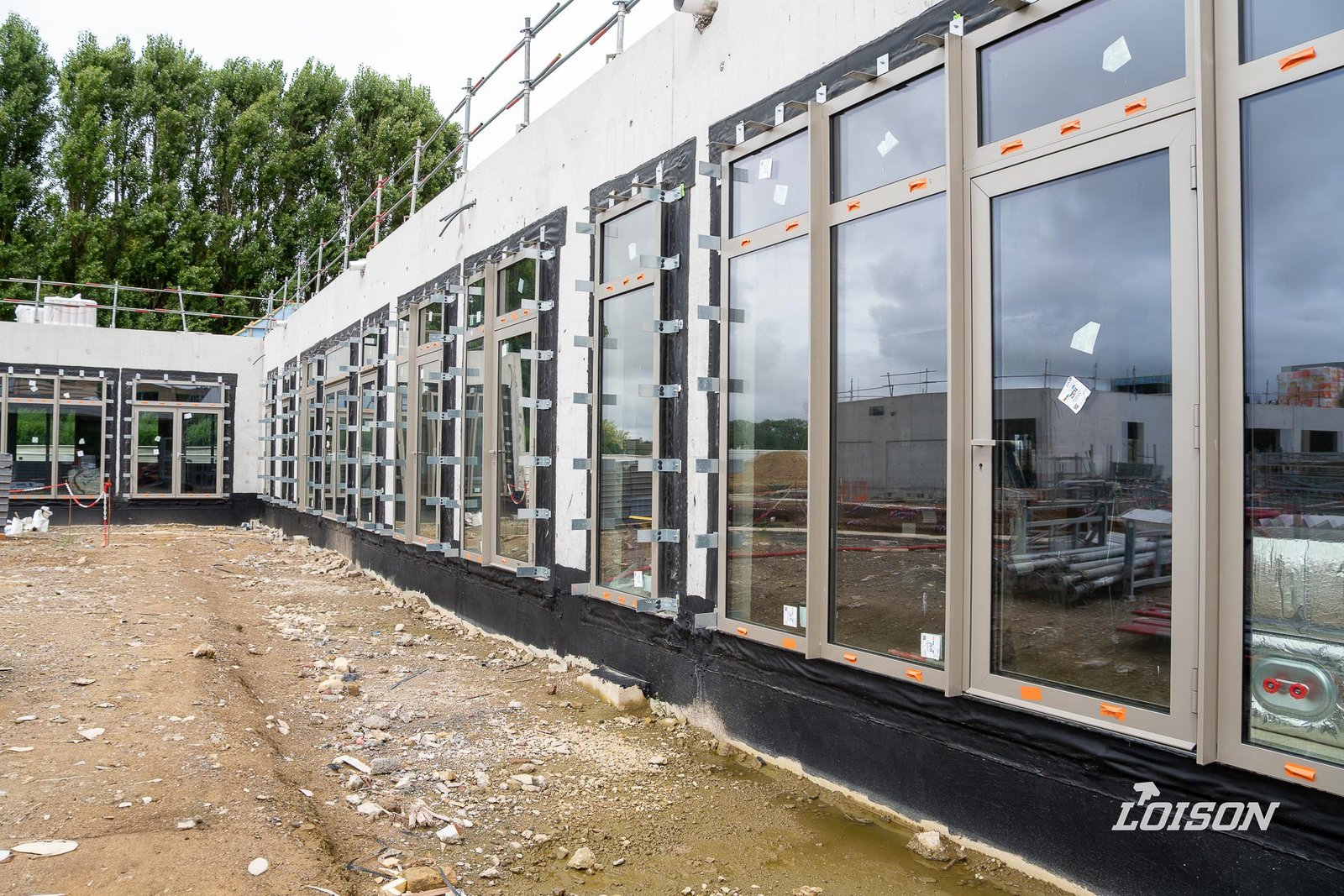 Collège Fernande Benoist - Hazebrouck Enfilade de menuiseries aluminium posées côté cour, avec leurs membranes d'étanchéité