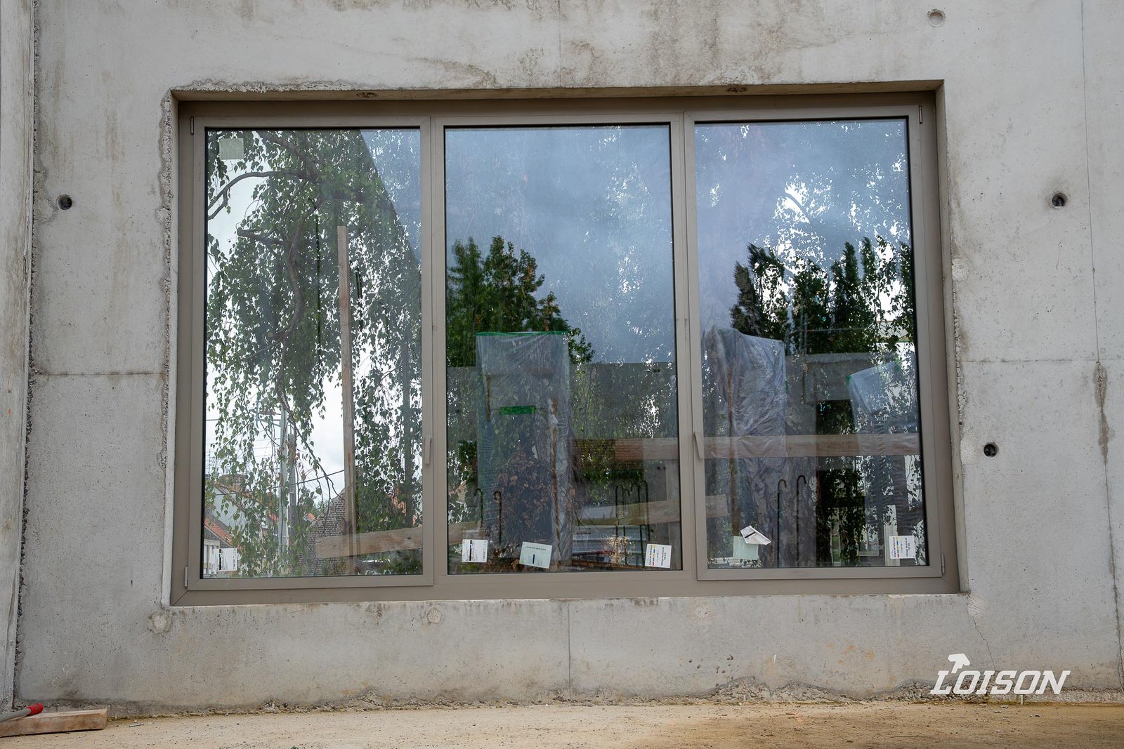 Collège Fernande Benoist - Hazebrouck Châssis à trois vantaux posé dans une façade en béton brut