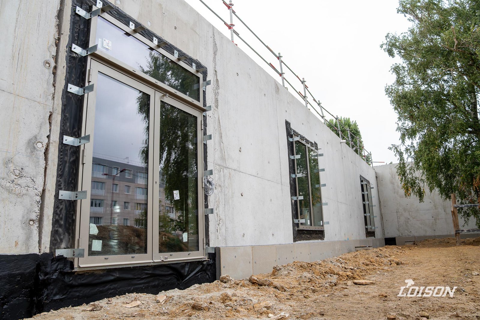 Collège Fernande Benoist - Hazebrouck Porte vitrée à deux vantaux sur une façade en béton