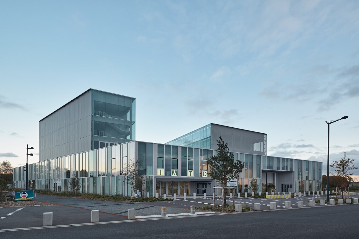 Façade d'entrée vitrée de l'IMTD et de l'IIM à Valenciennes, à la tombée du jour
