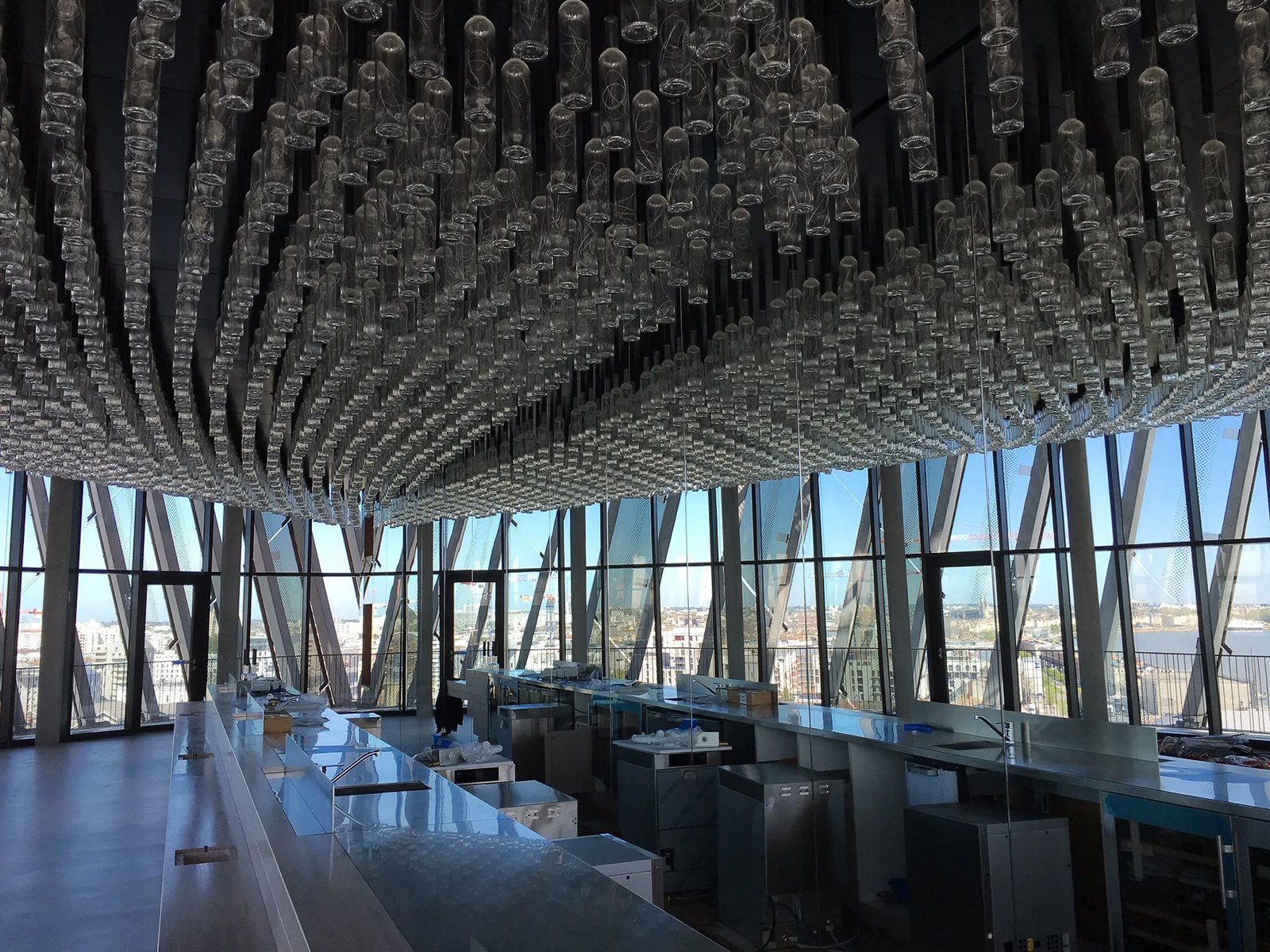 Le lustre de bouteilles du belvédère au-dessus du bar, en fin de chantier, avec vue sur Bordeaux