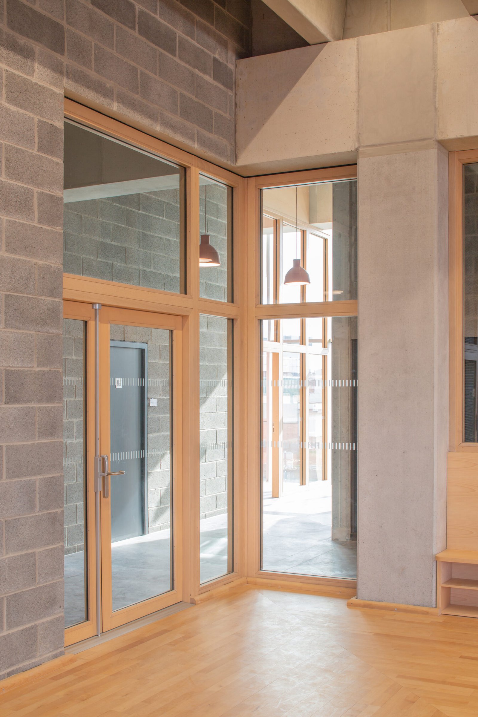 Salle multisports Saint-Sauveur - Lille Porte vitrée et châssis à menuiseries bois entre deux espaces
