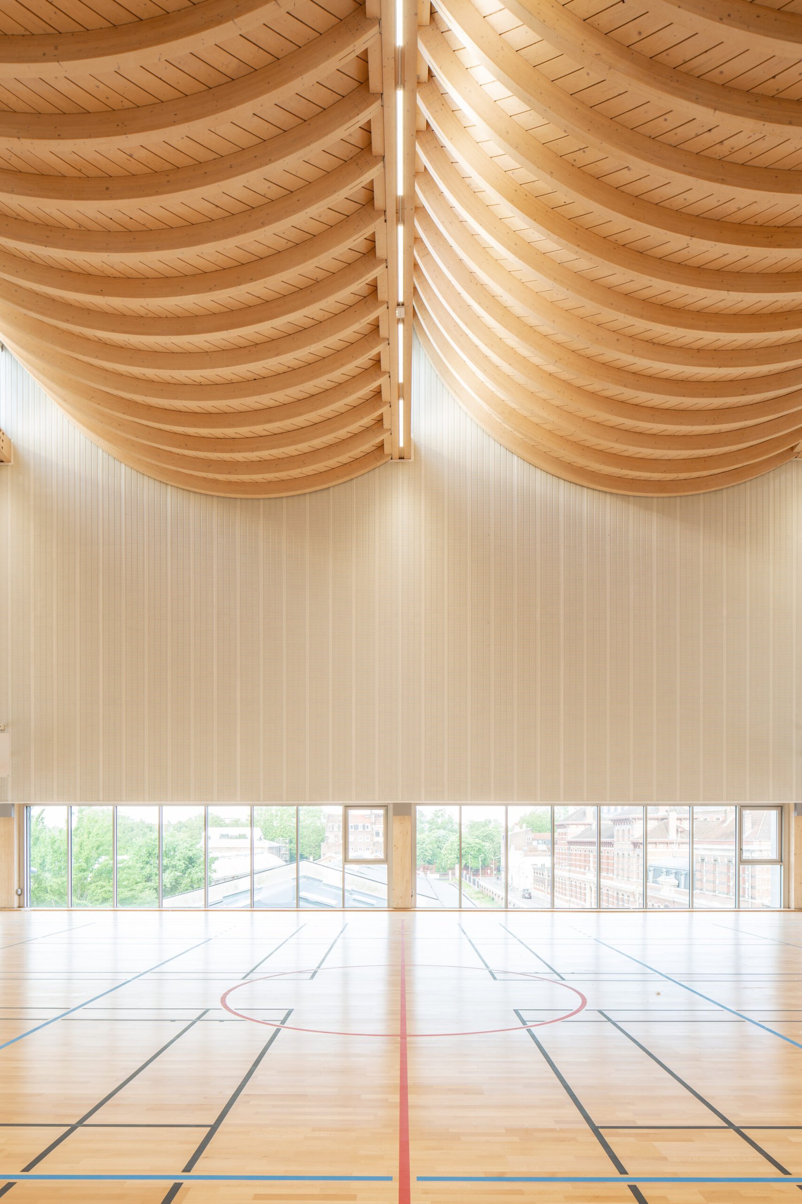Salle multisports Saint-Sauveur - Lille Les coques en bois de la charpente au-dessus de la salle de basket
