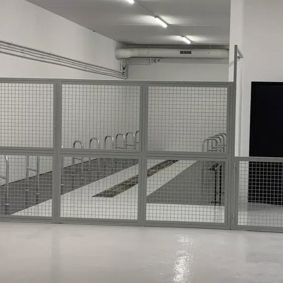 Local à vélos fermé par des grilles en acier
