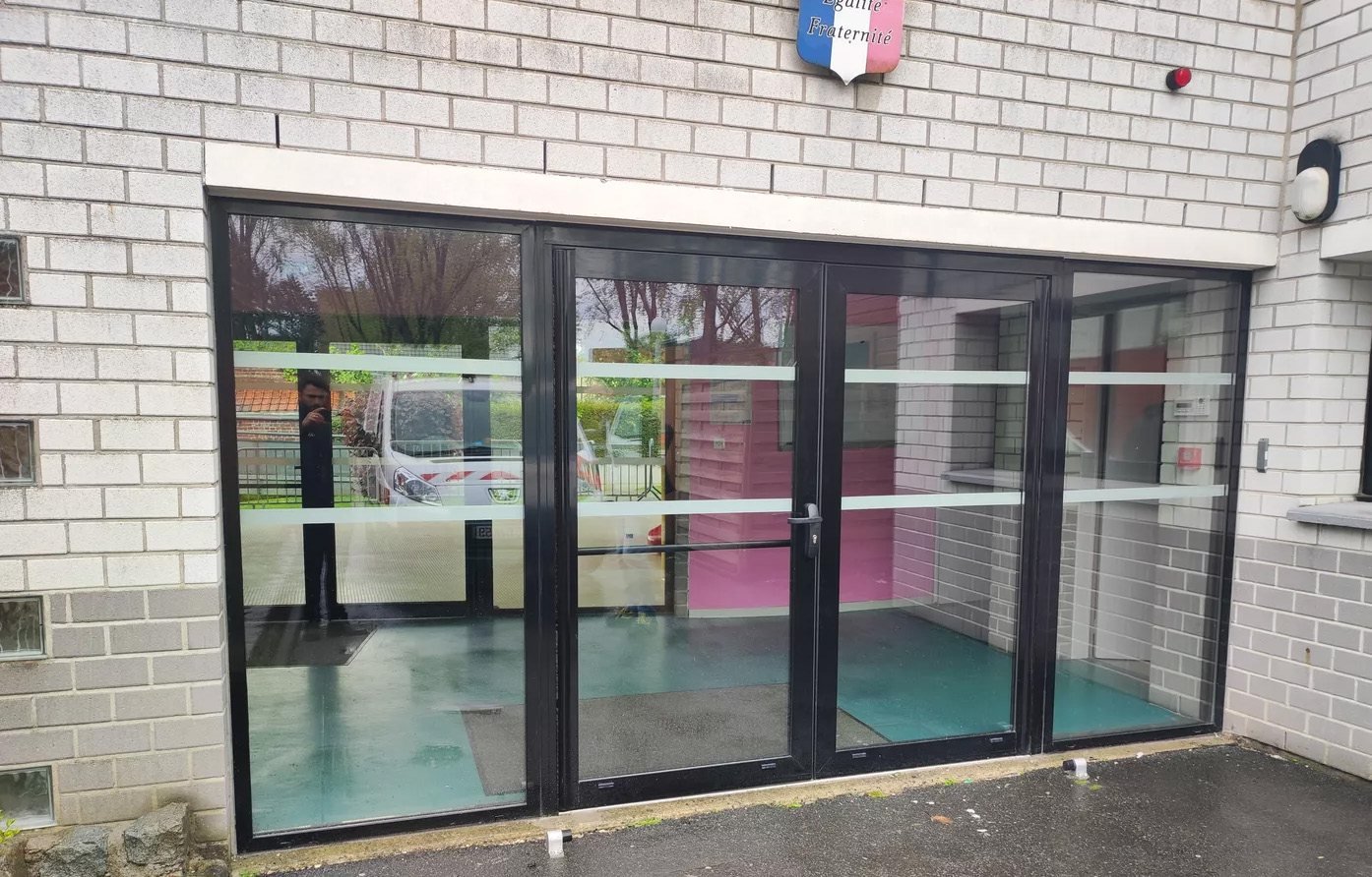 Porte d'entrée vitrée d'un bâtiment communal