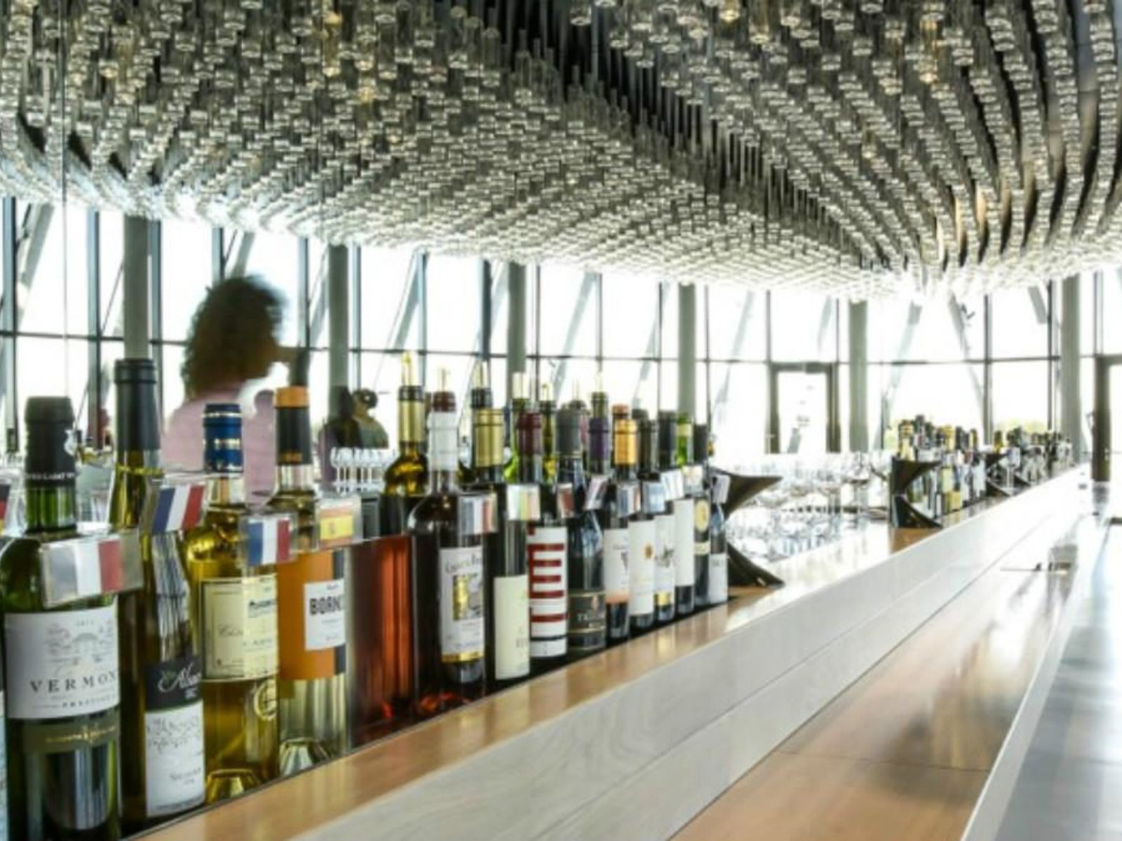 La Cité du Vin - Bordeaux Le bar du belvédère et ses bouteilles, sous le lustre
